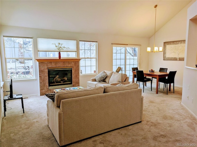 living area with a fireplace, lofted ceiling, light colored carpet, an inviting chandelier, and baseboards