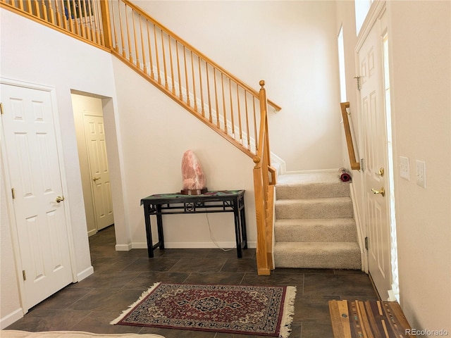 staircase with a high ceiling and baseboards