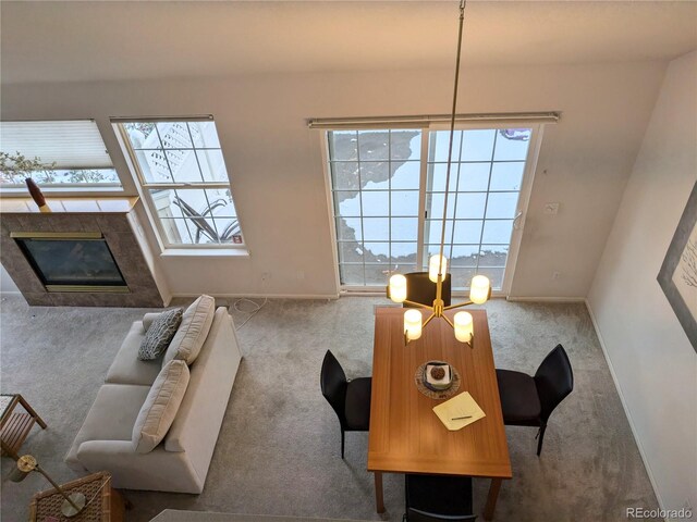 carpeted living room with a healthy amount of sunlight, a premium fireplace, and baseboards