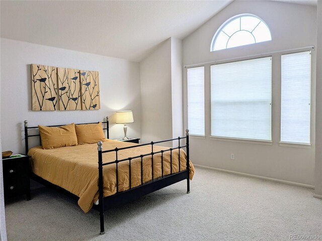 carpeted bedroom with lofted ceiling