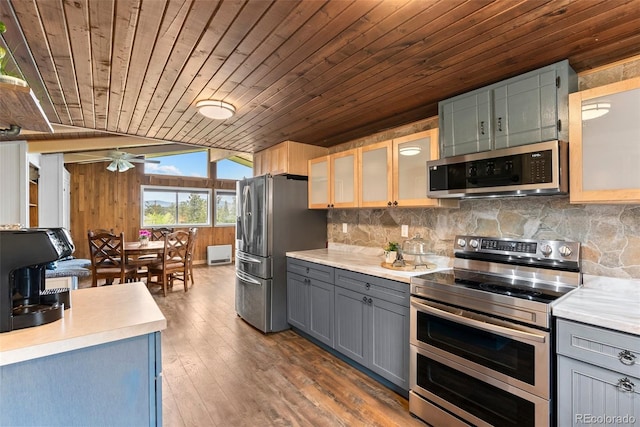 kitchen featuring appliances with stainless steel finishes, wood ceiling, vaulted ceiling, ceiling fan, and wood-type flooring