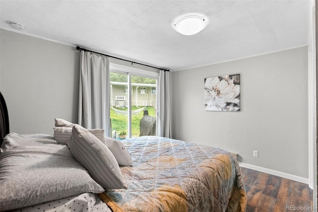 bedroom with a textured ceiling and dark hardwood / wood-style flooring