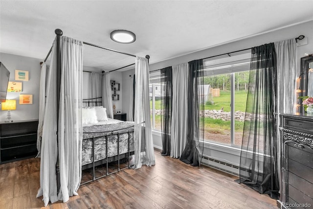 bedroom featuring hardwood / wood-style floors and baseboard heating