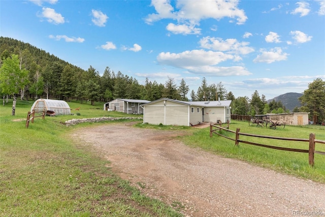 view of yard featuring a mountain view, an outbuilding, and a rural view