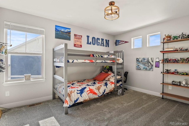 carpeted bedroom featuring baseboards, multiple windows, and visible vents