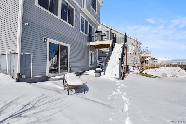 snow covered property featuring stairs