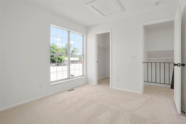16322 E Idaho Pl, Aurora, CO 80017 - unfurnished bedroom featuring attic access, carpet flooring, a walk in closet, and a closet