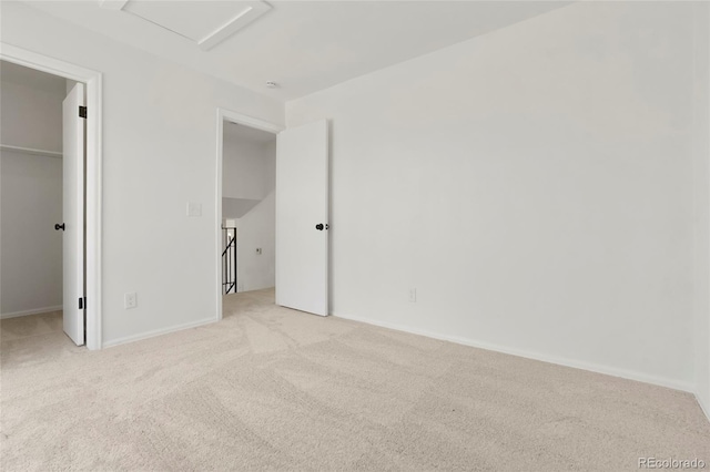 16322 E Idaho Pl, Aurora, CO 80017 - unfurnished bedroom featuring a spacious closet, light carpet, attic access, and a closet