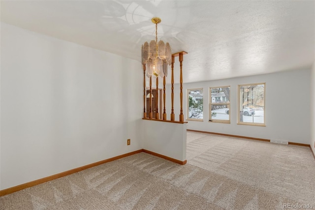 unfurnished living room featuring carpet, a textured ceiling, and a notable chandelier