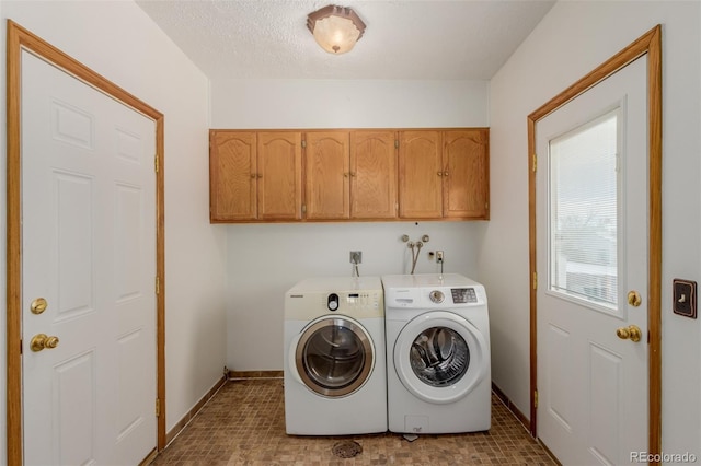 clothes washing area featuring cabinets, independent washer and dryer, and a textured ceiling