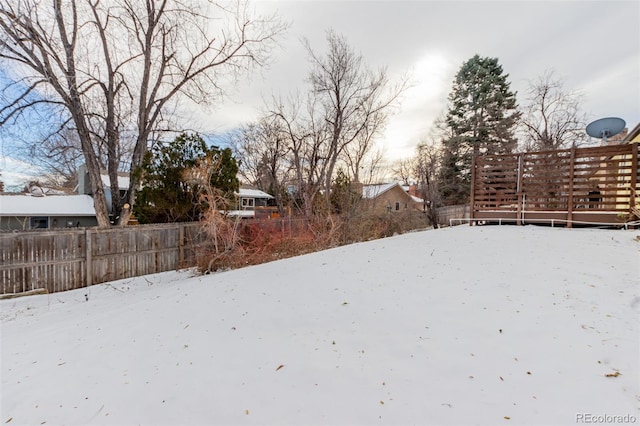 snowy yard featuring a wooden deck