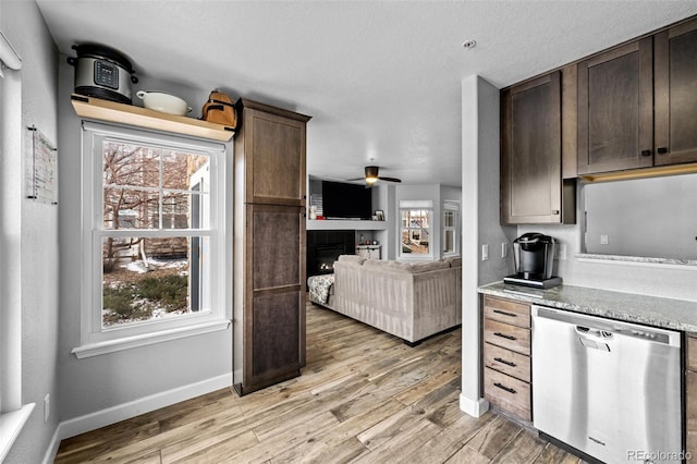 kitchen with stainless steel dishwasher, plenty of natural light, light wood-style flooring, and dark brown cabinetry