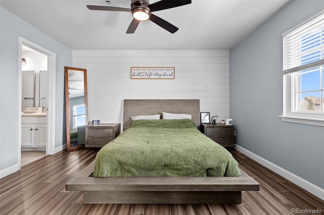 bedroom with ensuite bathroom, ceiling fan, wood finished floors, and baseboards