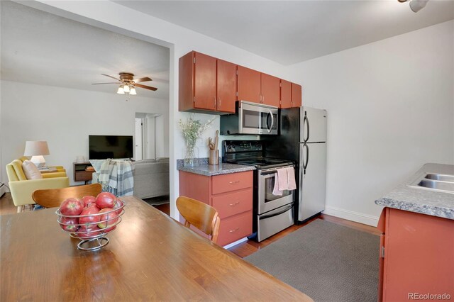 1201 Race St Unit 10, Denver, CO 80206 - kitchen featuring stainless steel appliances, ceiling fan, baseboards, dark wood-style flooring, and light countertops
