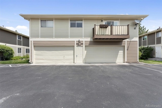 6650 E Arizona Ave Unit 203, Denver, CO 80224 - view of front of house featuring an attached garage, a balcony, and driveway