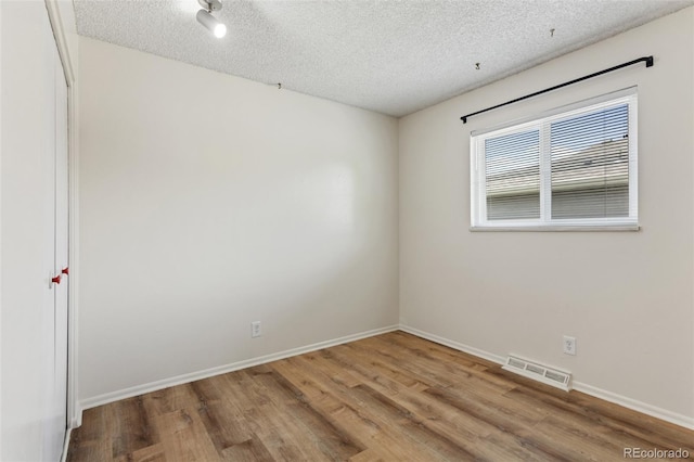 6650 E Arizona Ave Unit 203, Denver, CO 80224 - spare room featuring a textured ceiling, wood finished floors, and baseboards