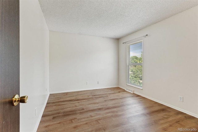 6650 E Arizona Ave Unit 203, Denver, CO 80224 - unfurnished room featuring wood finished floors, a textured ceiling, and baseboards