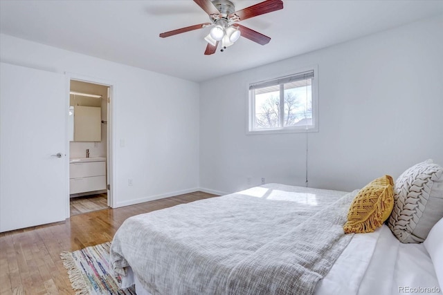 bedroom with wood-type flooring, ceiling fan, and ensuite bath