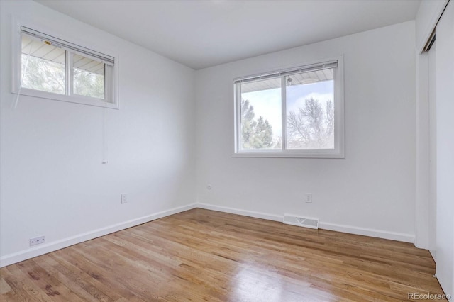 spare room with a wealth of natural light and light hardwood / wood-style flooring