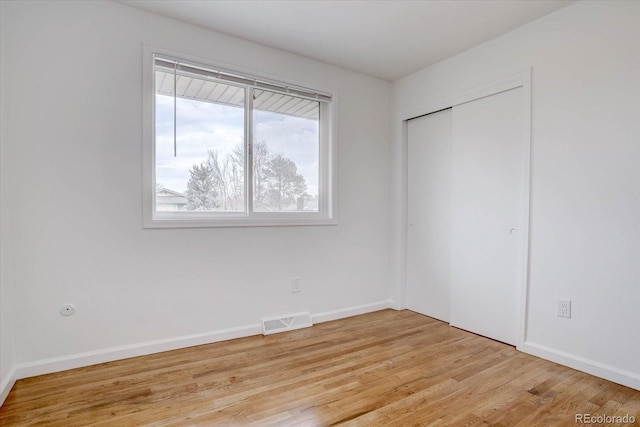 unfurnished bedroom with light hardwood / wood-style floors and a closet