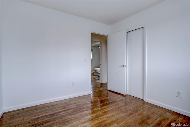 unfurnished bedroom with hardwood / wood-style floors and a closet