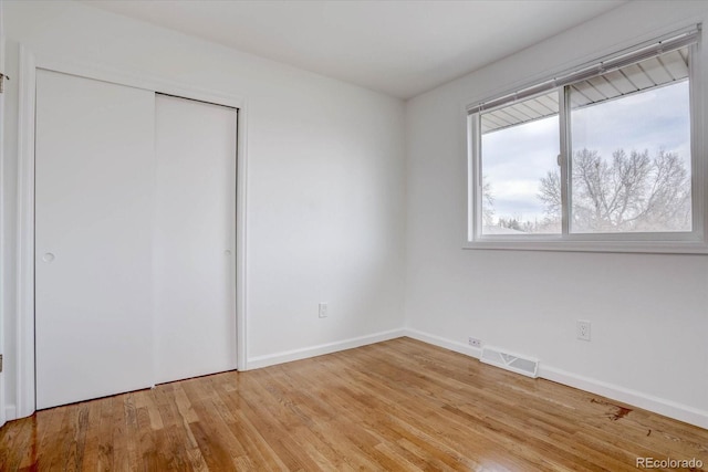 unfurnished bedroom with a closet and light hardwood / wood-style flooring