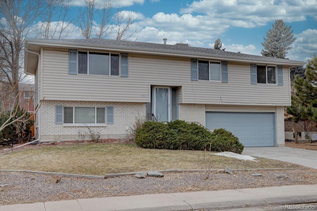 raised ranch with a garage and a front yard