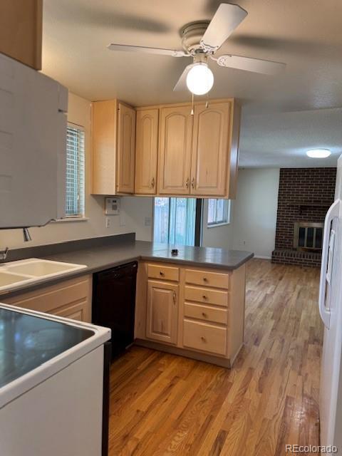 16180 E Flora Pl, Aurora, CO 80013 - kitchen with black dishwasher, light brown cabinetry, light wood-style flooring, and a peninsula