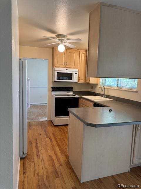 16180 E Flora Pl, Aurora, CO 80013 - kitchen with white microwave, electric stove, a sink, freestanding refrigerator, and a peninsula