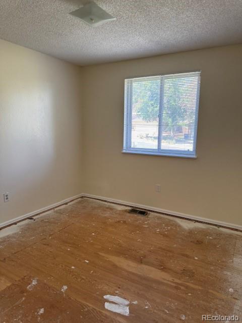 16180 E Flora Pl, Aurora, CO 80013 - empty room featuring a textured ceiling and baseboards