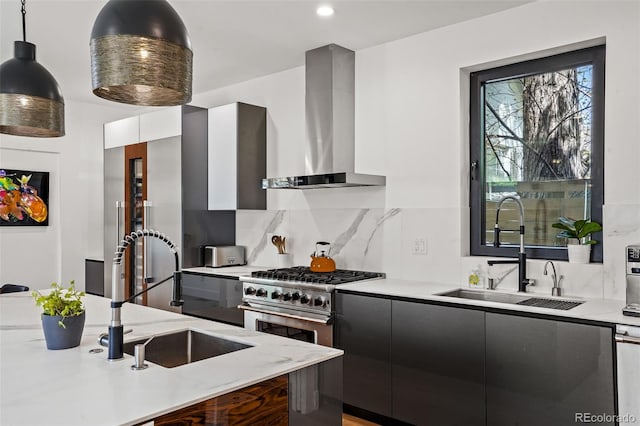 kitchen with a sink, wall chimney exhaust hood, high end stove, and modern cabinets