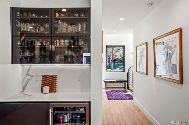bar with baseboards, recessed lighting, a dry bar, beverage cooler, and wood finished floors