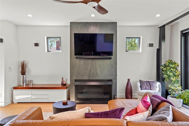 living area featuring recessed lighting, a fireplace, a ceiling fan, and wood finished floors