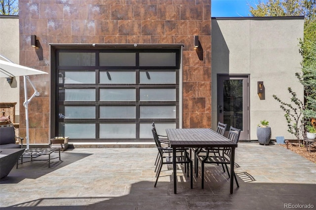 view of patio / terrace featuring outdoor dining space and a garage