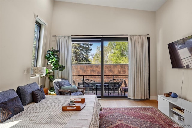 bedroom featuring access to outside and wood finished floors