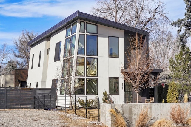 view of front facade featuring stucco siding and fence