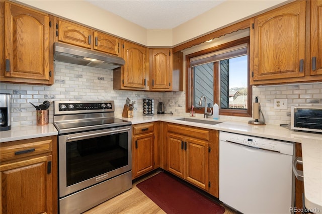 143 Forest Trl Unit 210, Winter Park, CO 80482 - kitchen featuring white dishwasher, stainless steel electric range oven, under cabinet range hood, a sink, and light countertops