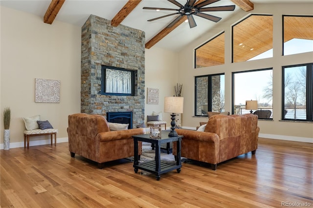 living room featuring a stone fireplace, plenty of natural light, and light hardwood / wood-style floors