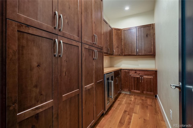 kitchen with light hardwood / wood-style flooring and beverage cooler