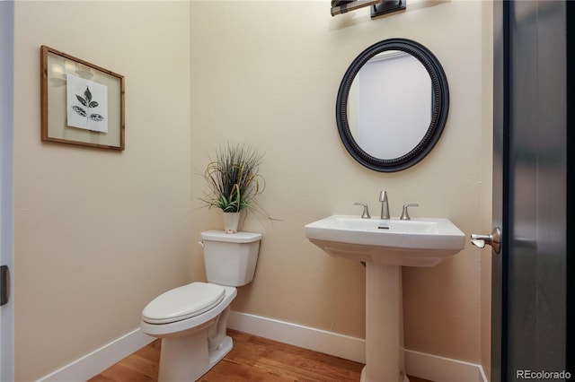 bathroom featuring hardwood / wood-style flooring and toilet