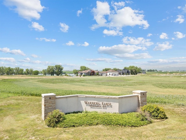 community / neighborhood sign featuring a yard and a rural view