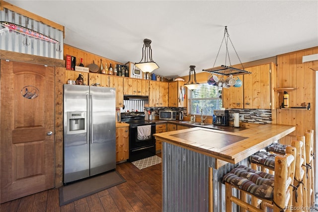246 Spruce Dr, Twin Lakes, CO 81251 - kitchen with appliances with stainless steel finishes, a sink, a peninsula, wooden walls, and decorative backsplash