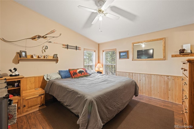 246 Spruce Dr, Twin Lakes, CO 81251 - bedroom with dark wood-style flooring, a wainscoted wall, vaulted ceiling, wooden walls, and ceiling fan