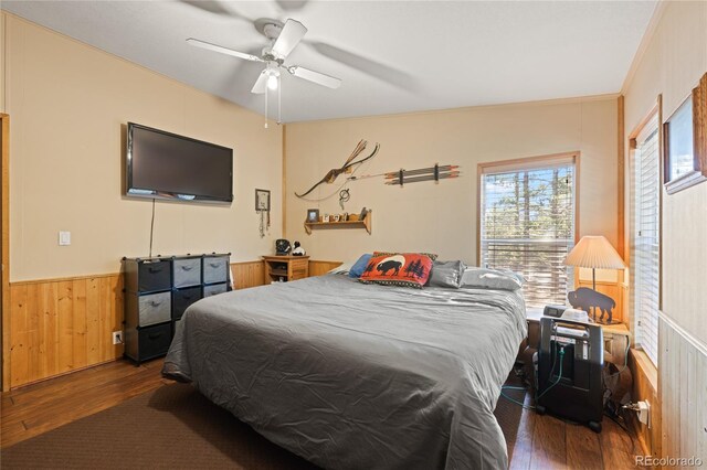 246 Spruce Dr, Twin Lakes, CO 81251 - bedroom featuring dark wood-style flooring, wood walls, a wainscoted wall, and a ceiling fan