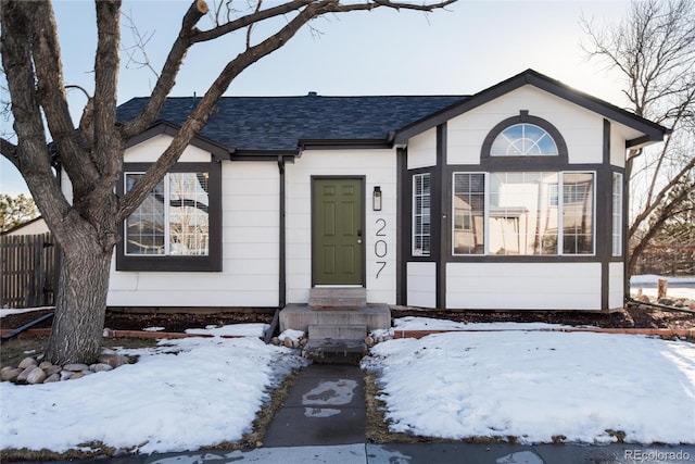 view of front of property featuring a shingled roof, entry steps, and fence