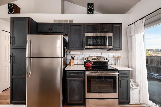 kitchen featuring light countertops, appliances with stainless steel finishes, visible vents, and tasteful backsplash