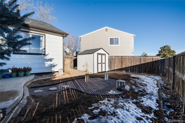 exterior space featuring roof with shingles, a fenced backyard, an outdoor structure, and a shed