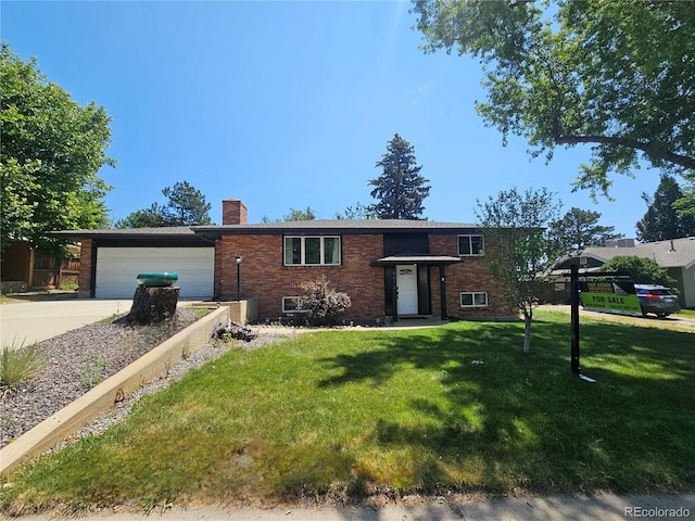 6614 Everett St, Arvada, CO 80004 - view of front facade with brick siding, a chimney, a garage, a front yard, and driveway