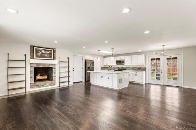 6614 Everett St, Arvada, CO 80004 - unfurnished living room with a large fireplace, recessed lighting, and dark wood finished floors