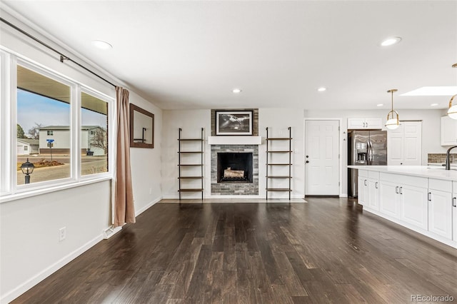 6614 Everett St, Arvada, CO 80004 - unfurnished living room with dark wood-style floors, recessed lighting, and a fireplace